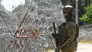 A border guard keeps guard at the Polish-Belarusian border, in the background you can see barbed wire at the Polish border post in Polovce