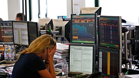 Bir tüccar, 22 Eylül 2011 Perşembe günü Paris'te bir iş bankasında ekranının önünde tepki veriyor.