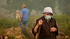 Les habitants marchent alors qu'un incendie de forêt avance vers le village de Rebordondo, près d'Ourense, dans le nord-ouest de l'Espagne, le lundi 18 août 2025.