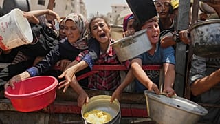 فلسطينيون يتدافعون للحصول على طعام مُقدَّم في مطبخ مجتمعي بمدينة غزة شمال القطاع، السبت 16 أغسطس 2025.