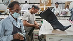 Arbeiter in einer Produktionsstätte stellen Lederschuhe in Agra, Indien, her. 25. Aug. 2025.