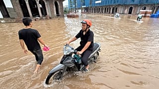 Varias personas conducen motocicletas en una calle inundada tras el paso del tifón Kajiki por Hanoi, Vietnam, el miércoles 27 de agosto de 2025.