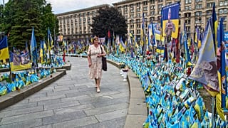 Uma mulher olha para um memorial improvisado para os soldados mortos na guerra Rússia-Ucrânia na Praça da Independência em Kiev, Ucrânia, quarta-feira, 9 de julho de 2025.