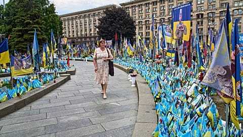 Egy nő az orosz-ukrán háborúban elesett katonák emlékművét nézi az ukrajnai Kijevben, a Függetlenség téren 2025. július 9-én, szerdán.