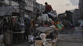 نازحون فلسطينيون من جباليا يحملون أغراضهم في شوارع غزة، الثلاثاء 26 أغسطس 2025.