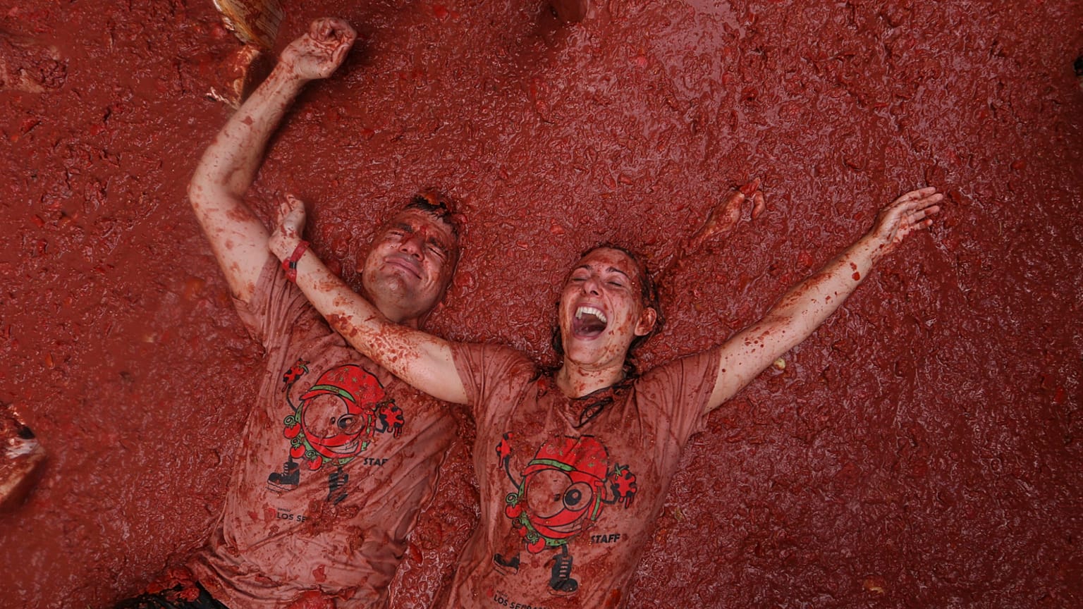 Un couple réagit alors que des fêtards se lancent des tomates lors de la fête annuelle de la "Tomatina" dans le village de Buñol près de Valence, en Espagne, mercredi 27 août 2025