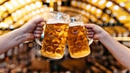 Dos personas chocan vasos de cerveza en una carpa del Oktoberfest en Alemania