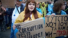 Teilnehmer halten Transparente während einer Demonstration gegen ein Gesetz, das auf die Korruptionsbekämpfung abzielt, vor dem Präsidialamt in Kiew, Ukraine, 30. Juli 2025.