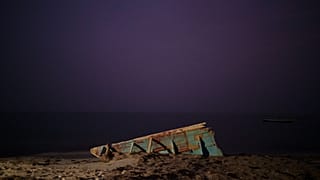 wreck of a traditional Mauritanian fishing boat known as a pirogue, also used by migrants to reach Spain's Canary Islands, sits on a beach near Nouadhibou, Mauritania (2021)