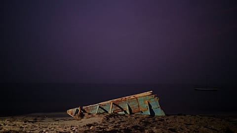 wreck of a traditional Mauritanian fishing boat known as a pirogue, also used by migrants to reach Spain's Canary Islands, sits on a beach near Nouadhibou, Mauritania (2021)