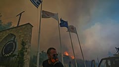 Kıbrıs'ın Omodos köyünde, Doğu Akdeniz adasının güneyinde çıkan büyük orman yangını sırasında köy sakinleri alevleri söndürmeye çalışıyor.