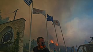 Kıbrıs'ın Omodos köyünde, Doğu Akdeniz adasının güneyinde çıkan büyük orman yangını sırasında köy sakinleri alevleri söndürmeye çalışıyor.