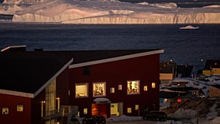 Public school pupils are seen inside their classrooms backdropped by large icebergs in the city of Ilulissat, Greenland, on Feb.19, 2025.