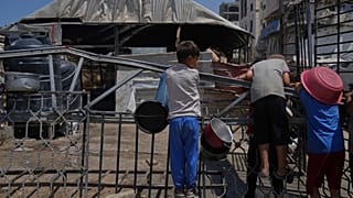 أطفال فلسطينيون ينتظرون في مطبخ مجتمعي قبل إعداد وتوزيع الطعام المتبرع به في مدينة غزة, يوم الجمعة, أغسطس. 22, 2025.