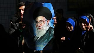 رجل يحمل ملصقًا للمرشد الأعلى الإيراني آية الله علي خامنئي، طهران، إيران، الثلاثاء، 11 شباط/فبراير 2014. 