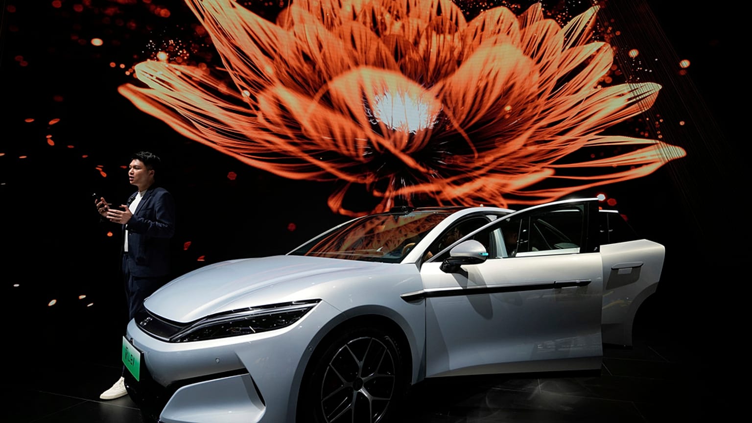 Bir adam 23 Nisan 2025 Çarşamba günü Şanghay otomobil fuarı sırasında BYD'nin Han L EV modelinin yanında konuşuyor. 