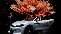 Bir adam 23 Nisan 2025 Çarşamba günü Şanghay otomobil fuarı sırasında BYD'nin Han L EV modelinin yanında konuşuyor. 