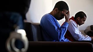 FILE: Alexanda Amon Kotey, left, and El Shafee Elsheikh sit on a sofa during an interview with AP at a security centre in Kobani, 30 March 2018