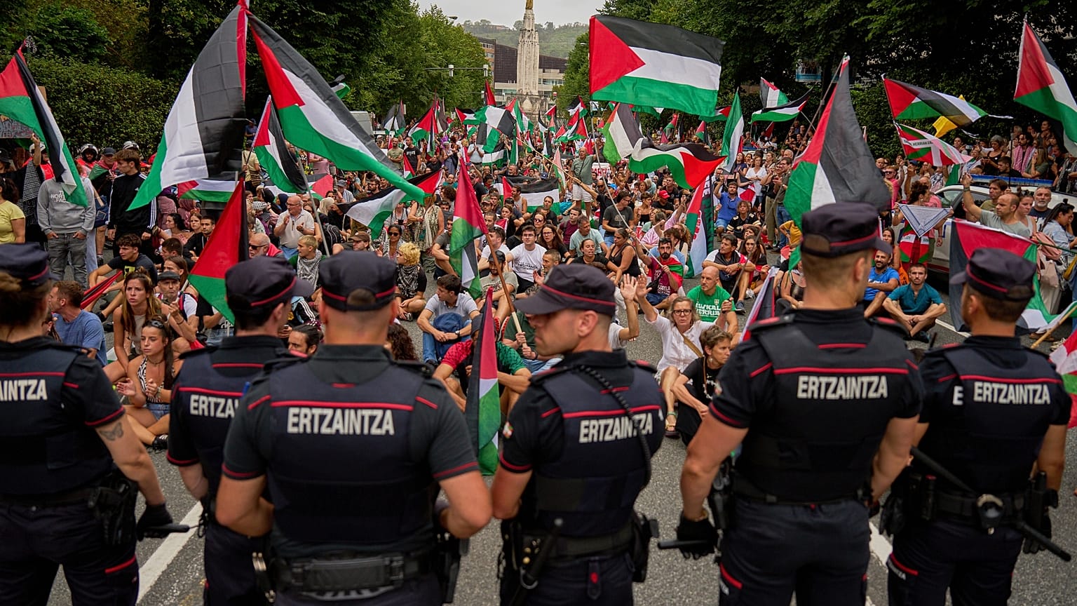 Personas con banderas palestinas se sientan en la calle después de interrumpir la undécima etapa de la carrera ciclista de la Vuelta a España, España, el 3 de septiembre.