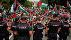 Personas con banderas palestinas se sientan en la calle después de interrumpir la undécima etapa de la carrera ciclista de la Vuelta a España, España, el 3 de septiembre.