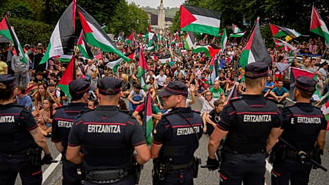 Personas con banderas palestinas se sientan en la calle después de interrumpir la undécima etapa de la carrera ciclista de la Vuelta a España, España, el 3 de septiembre.
