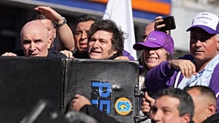 Η αστυνομία προστατεύει τον πρόεδρο της Αργεντινής Χαβιέρ Μιλέι και την αδελφή του, Καρίνα, από αντικείμενα που τους πετούν οι διαδηλωτές.