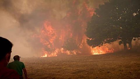 Residents fight a forest fire advancing towards the village of Rebordondo, near Ourense, in north-west Spain, on Monday 18 August 2025.