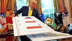 resident Donald Trump holds charts as he speaks about the economy in the Oval Office of the White House, 7 August, 2025, in Washington.