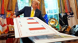 resident Donald Trump holds charts as he speaks about the economy in the Oval Office of the White House, 7 August, 2025, in Washington.