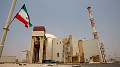 صورة تعبيرية.. يرفرف العلم الإيراني أمام مبنى المفاعل في محطة بوشهر للطاقة النووية، خارج مدينة بوشهر الجنوبية في إيران