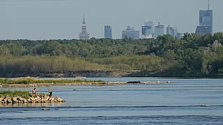 Deux hommes pêchent dans la Vistule, la plus longue rivière de Pologne, touchée par la sécheresse, à Varsovie le samedi 4 juillet 2025.