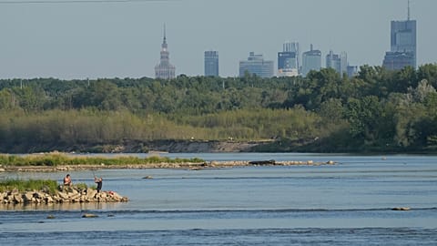 Deux hommes pêchent dans la Vistule, la plus longue rivière de Pologne, touchée par la sécheresse, à Varsovie le samedi 4 juillet 2025.
