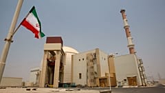 صورة أرشيفية - علم إيراني أمام مبنى المفاعل في محطة بوشهر للطاقة النووية، خارج مدينة بوشهر الجنوبية في إيران، يوم السبت 21 أغسطس/آب 2010.