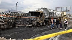 People walk past the wreckage of a fuel truck destroyed in Israeli airstrikes in Sanaa, 25 August, 2025