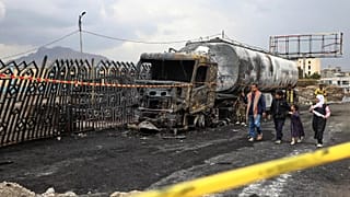 People walk past the wreckage of a fuel truck destroyed in Israeli airstrikes in Sanaa, 25 August, 2025