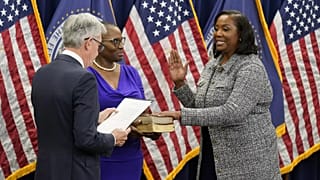 Lisa Cook, right, takes the oath of office to become a member of the Federal Reserve Board, May 23, 2022, in Washington. 