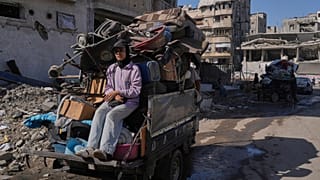 Displaced Palestinians fleeing northern Gaza Strip move with their belongings on a street in Gaza City, Thursday, Aug. 28, 2025. 