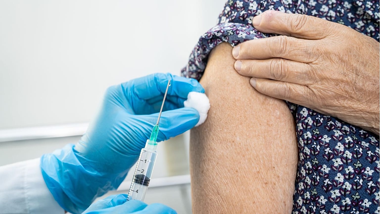 An older woman receives a vaccine.