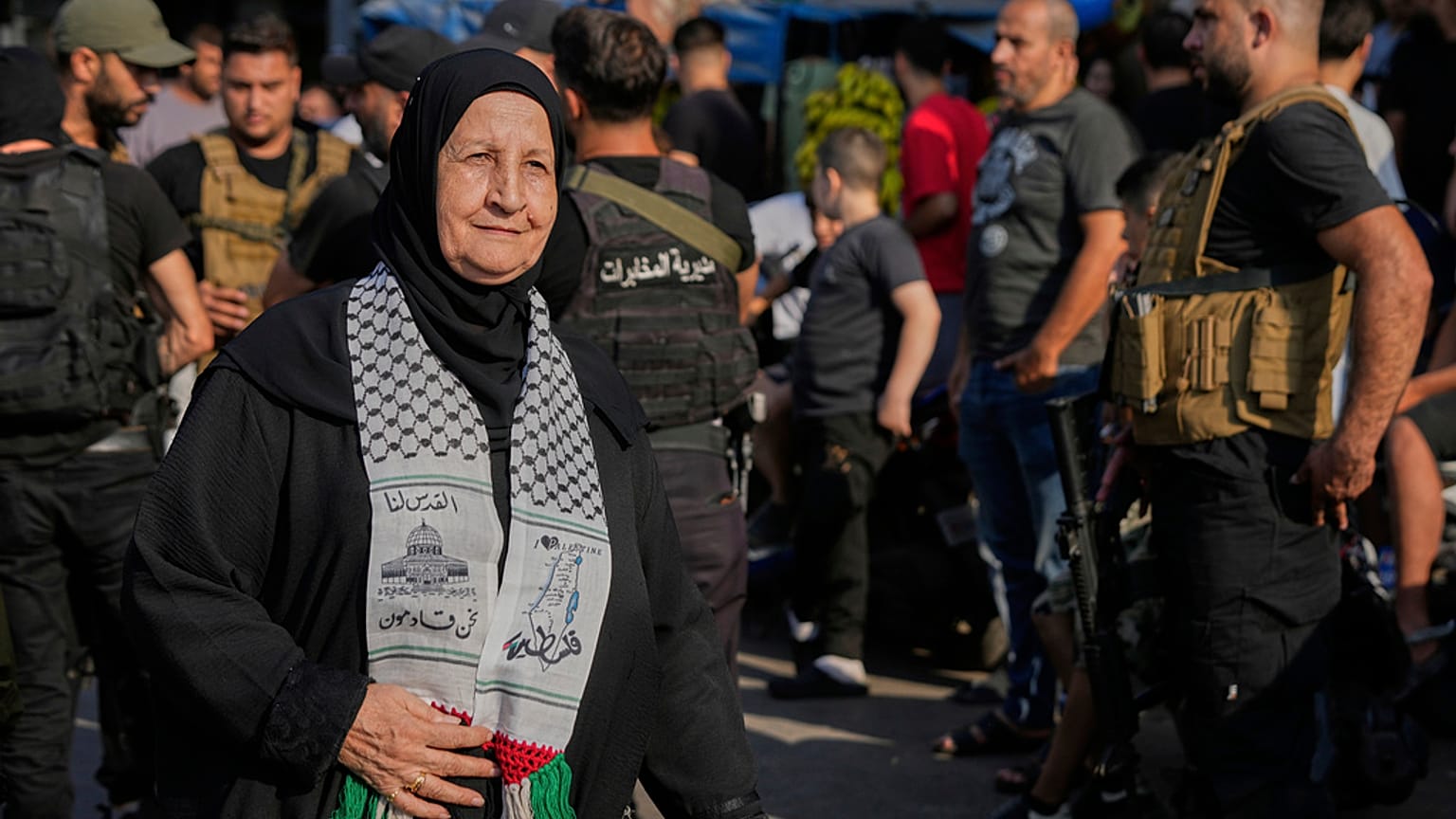 لاجئة فلسطينية في لبنان تمر بجانب قوات الأمن اللبنانية عند مخيم برج البراجنة للاجئين الفلسطينيين أثناء تسليم الفصائل الفلسطينية أسلحتها للجيش اللبناني، الخميس 21 أغسطس 2025