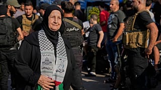 لاجئة فلسطينية في لبنان تمر بجانب قوات الأمن اللبنانية عند مخيم برج البراجنة للاجئين الفلسطينيين أثناء تسليم الفصائل الفلسطينية أسلحتها للجيش اللبناني، الخميس 21 أغسطس 2025