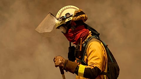 A firefighter works as a wildfire advances toward Rebordondo village, near Ourense, in northwestern Spain, Monday, Aug. 18, 2025. 