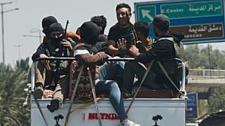 صورة تعبيرية لمقاتلين بدو مسلحين يركبون في الجزء الخلفي من شاحنة صغيرة أثناء عودتهم من محافظة السويداء الجنوبية إلى دمشق، سوريا