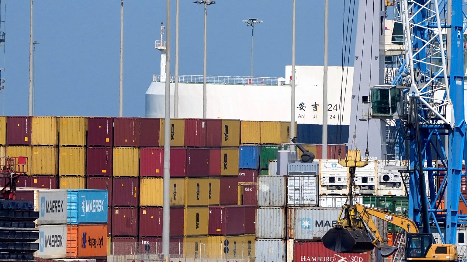Stacks of containers stand near a cargo ship in the Civitavecchia Harbour, Italy, Thursday, Aug. 7, 2025.