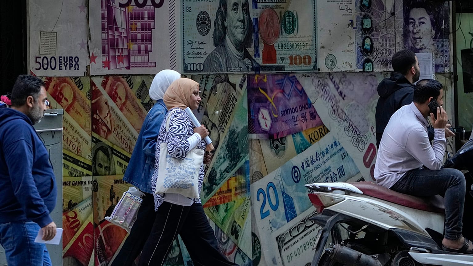 أشخاص يمرون أمام مكتب صرافة في القاهرة، مصر