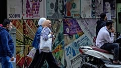 أشخاص يمرون أمام مكتب صرافة في القاهرة، مصر