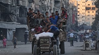 فلسطينيون يستقلّون شاحنة تحمل مساعدات إنسانية في أحد شوارع مدينة غزة، يوم الجمعة 29 آب/أغسطس 2025. 