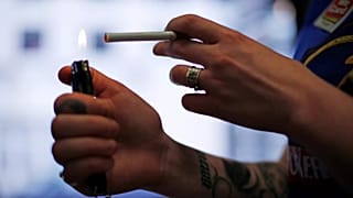 تُشعل مديرة متجر Smoker Friendly ستيفاني هانت سيجارة "مارلبورو" بمدينة بيتسبرغ، 17 تموز/يوليو 2015.