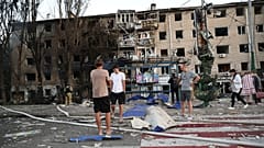 Anwohner stehen in der Nähe ihres zerstörten Hauses nach einem russischen Luftangriff in Saporischschja, Ukraine, Samstag, 30. August 2025. (AP Photo/Kateryna Klochko)