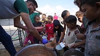 أطفال فلسطينيون نازحون يصطفون للحصول على الطعام في أحد المخيمات في دير البلح، قطاع غزة، يوم الجمعة 18 أكتوبر 2024