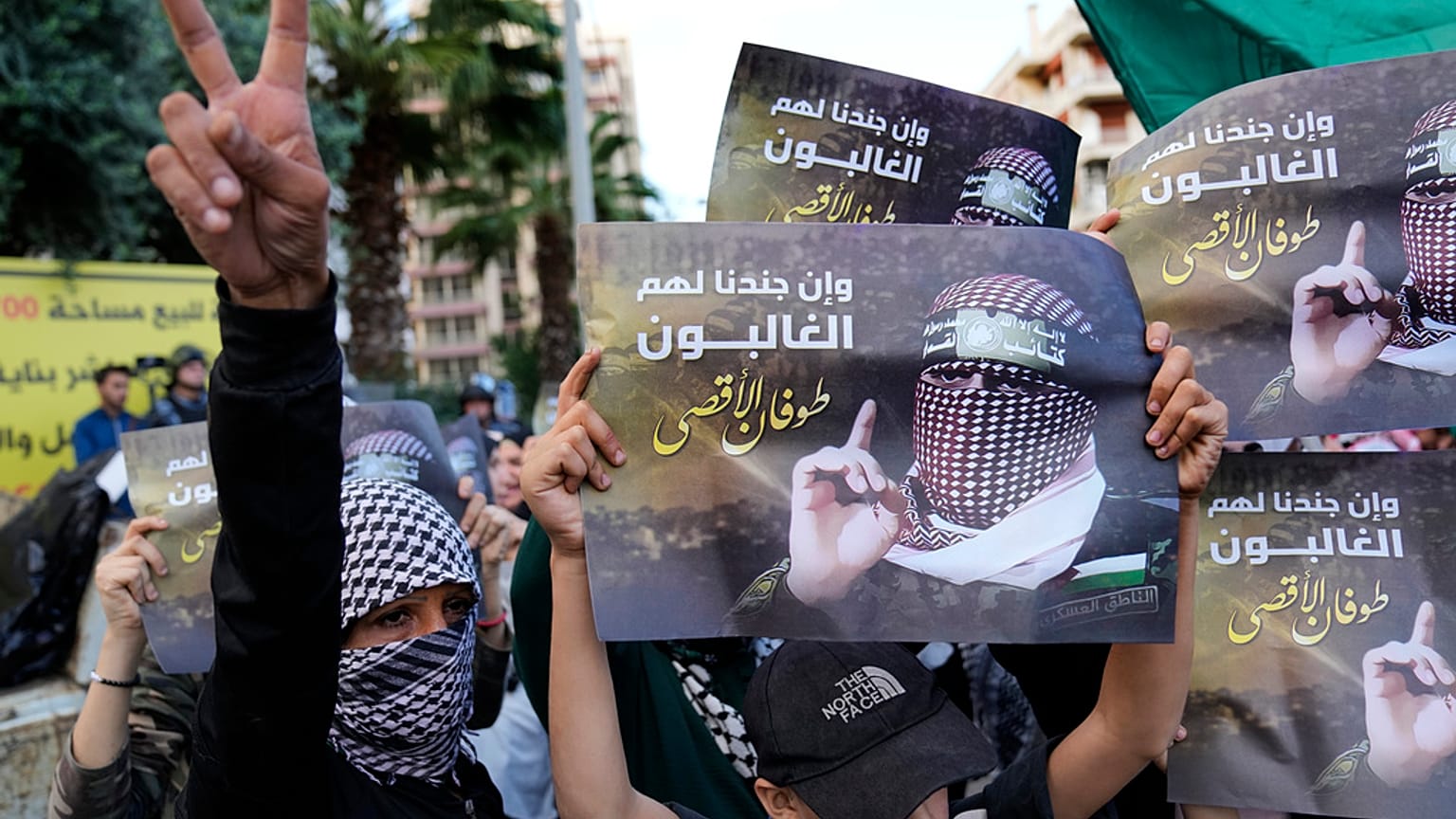 يظهر أحد المتظاهرين الفلسطينيين إشارة النصر، بينما يحمل آخرون صورًا لأبو عبيدة، المتحدث باسم كتائب القسام،بالقرب من السفارة المصرية في بيروت، لبنان، يوم السبت، 18 نوفمبر 2023.